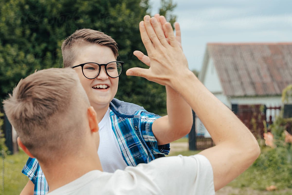 Happy Teenage Boy Sharing a High-Five with Dad on Back to School