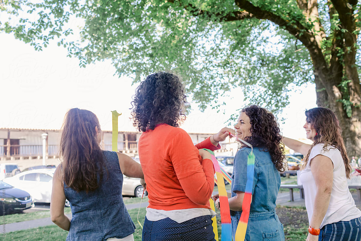 Content women playing with ribbons in park