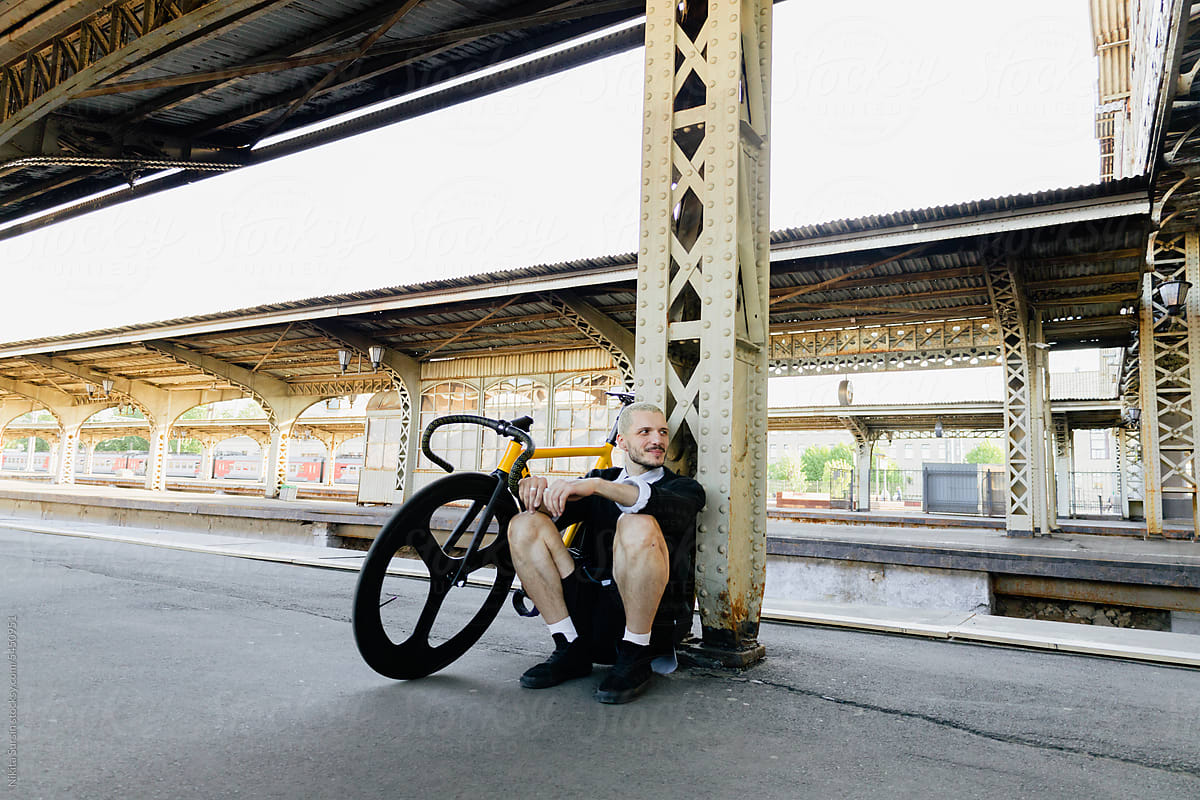 man on bicycle on train station travelling to countryside