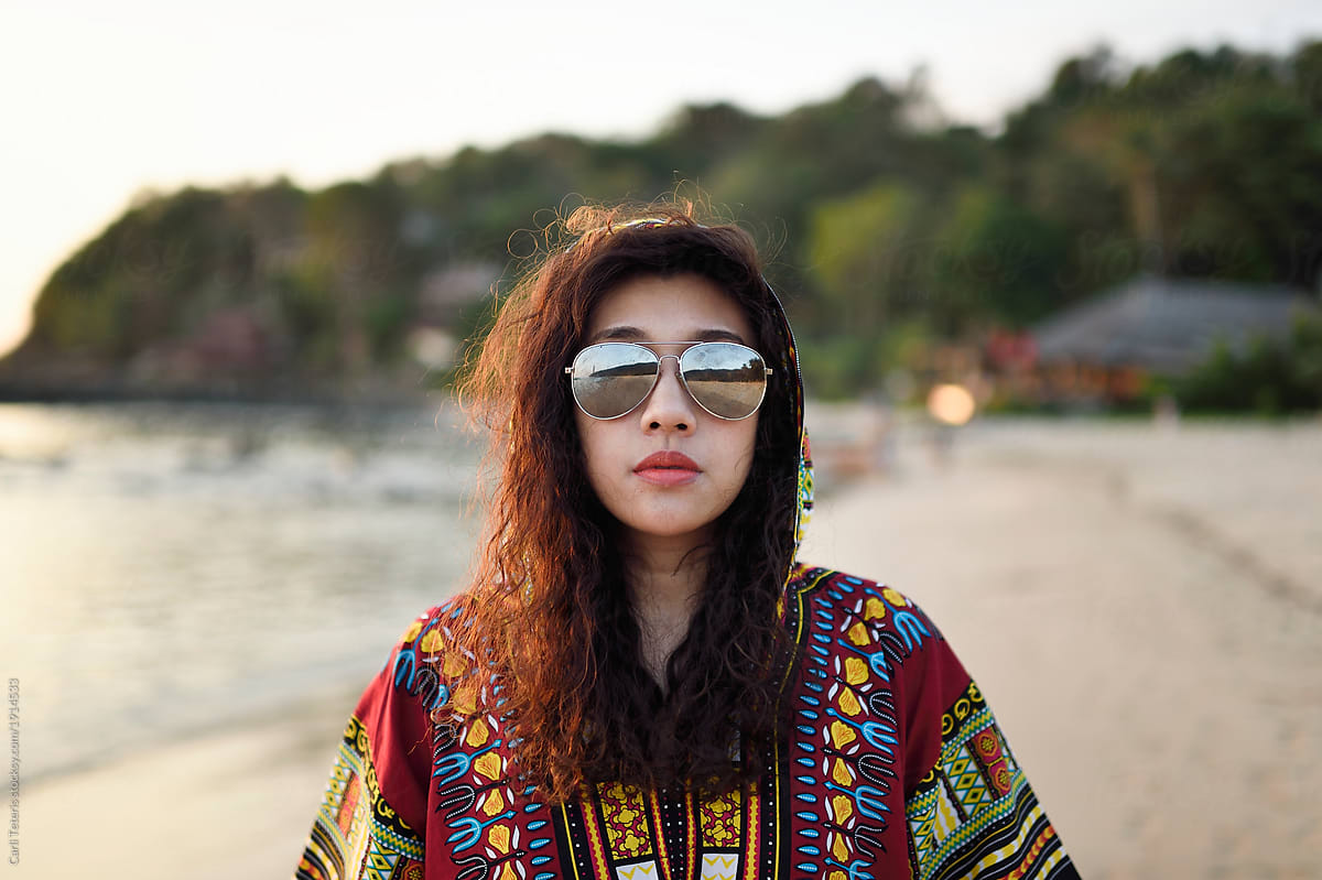 Fashionable Thai woman with permed hair on a tropical beach at dusk