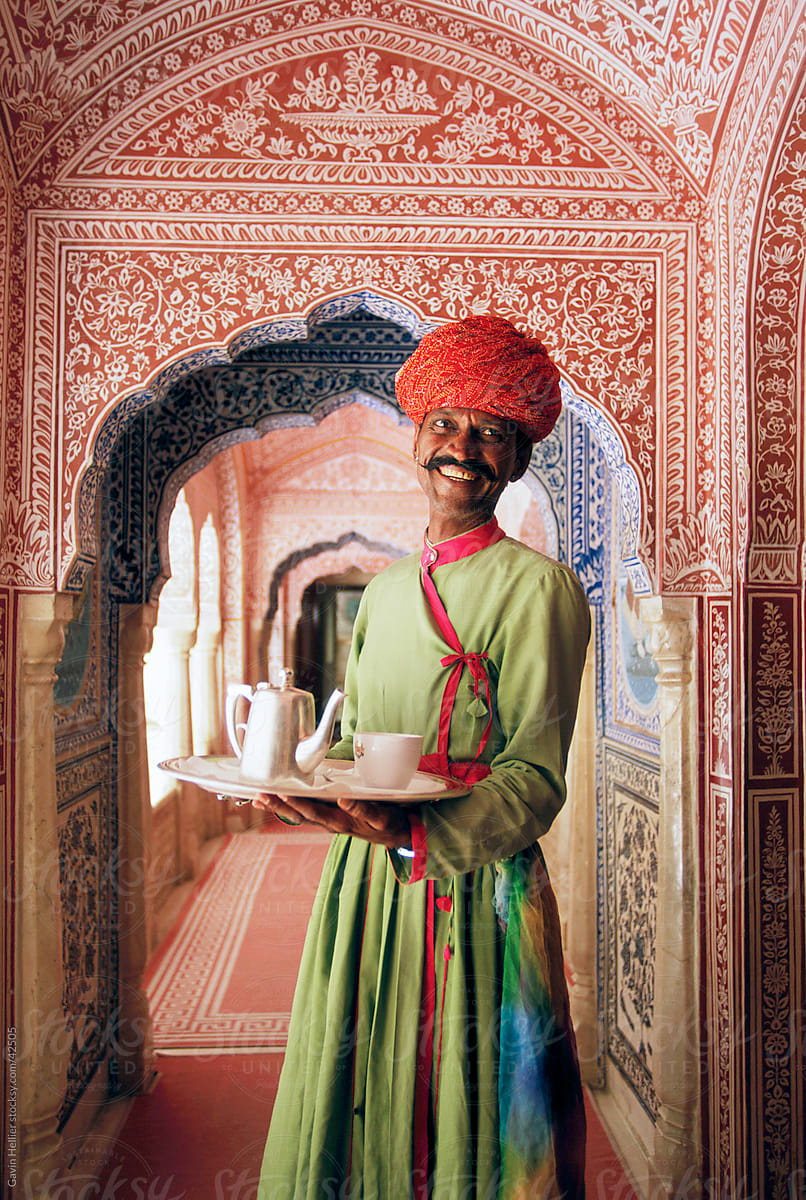 India, Jaipur, Samode Palace, waiter with tea tray in ornate hall