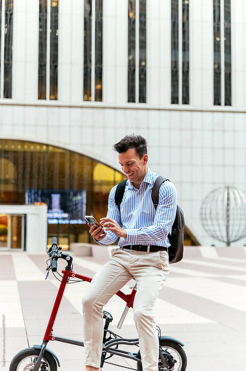 Male manager using smartphone on bike