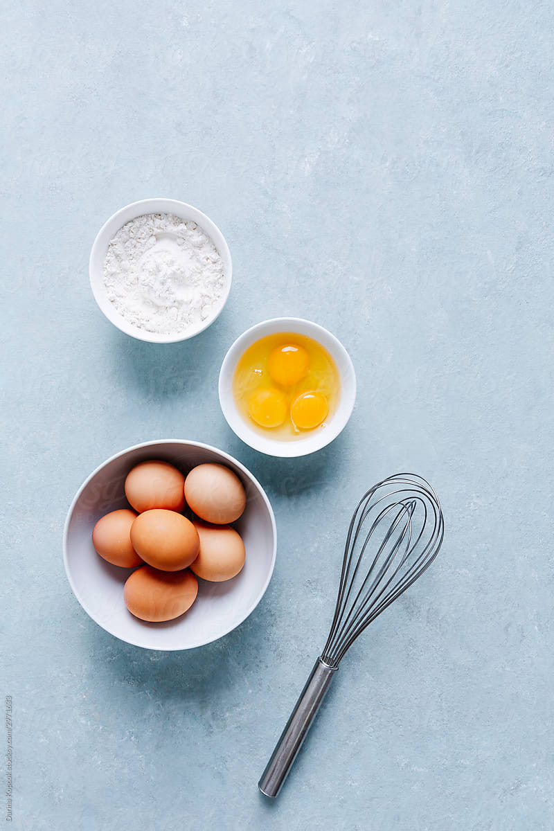 Bowl of Eggs with Whisk and Egg Yolks and Flour