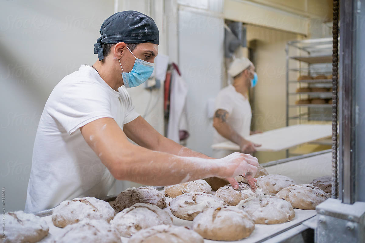 Employee Working Spreading Flour In A Bread Factory.
