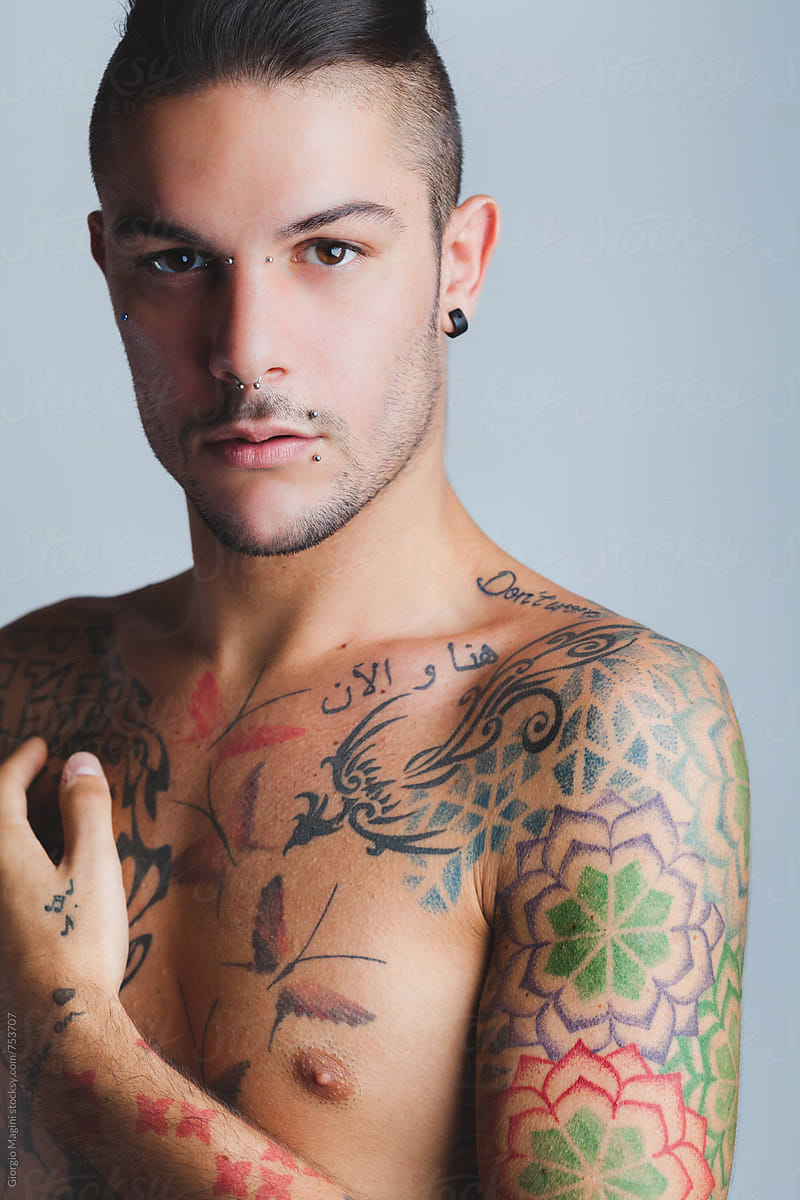 Studio Portrait Of A Sexy Young Man With Piercings And Tattoos