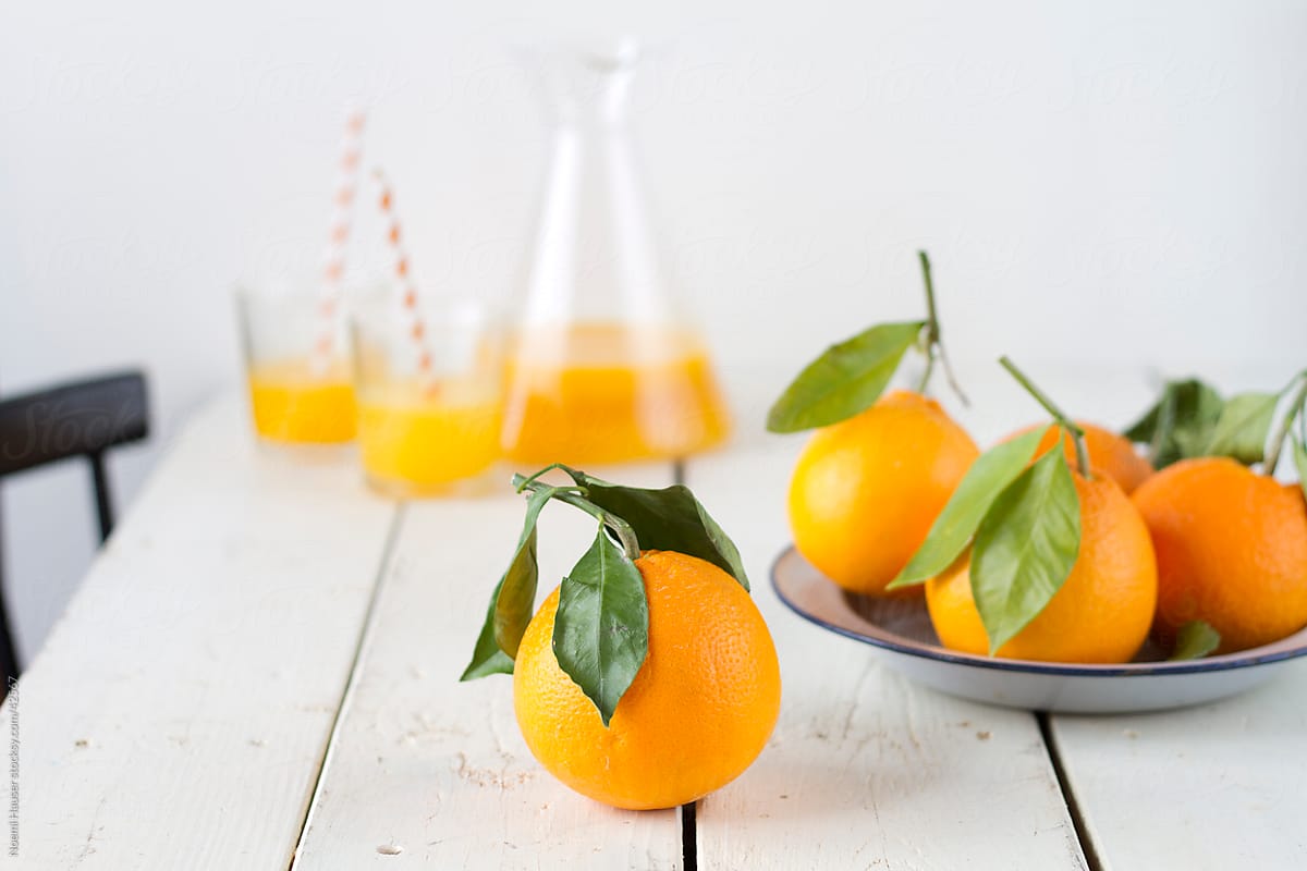 Fresh oranges and orange juice with paper straw