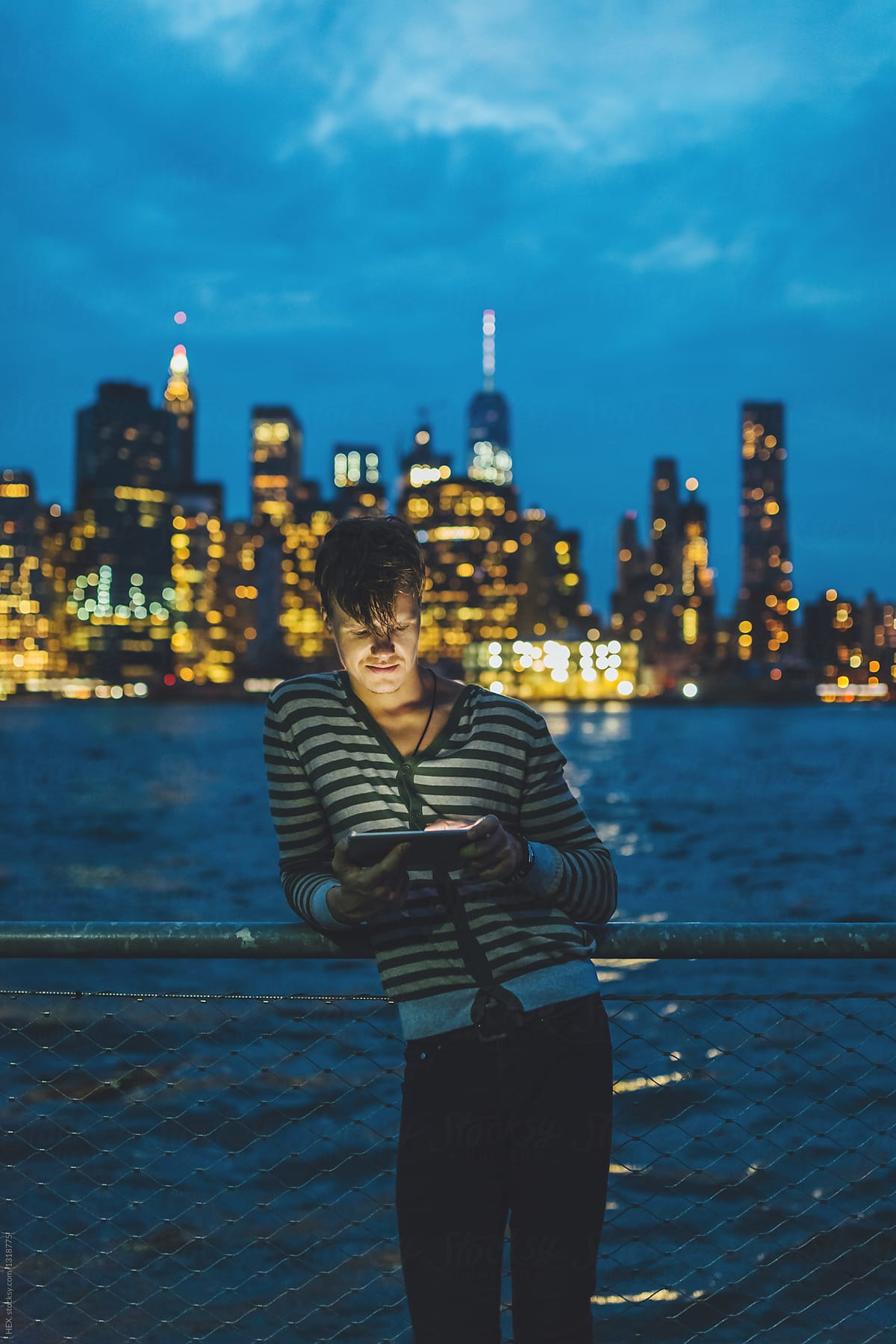 Young Man Using a Digital Tablet for Discovering New York During The Night . US