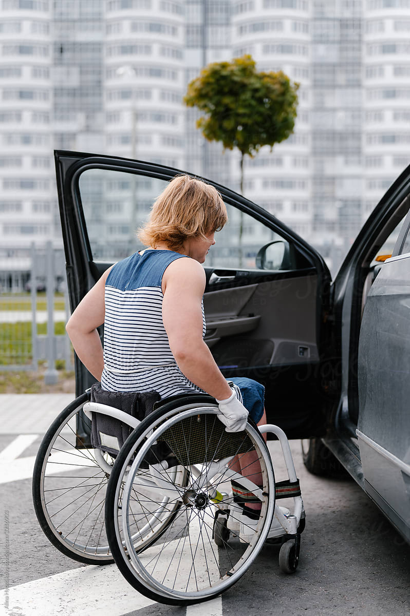 Adult woman on wheelchair getting into vehicle