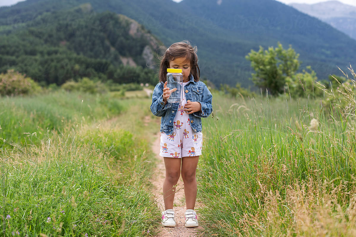 little girl holding a jar with butterflies in