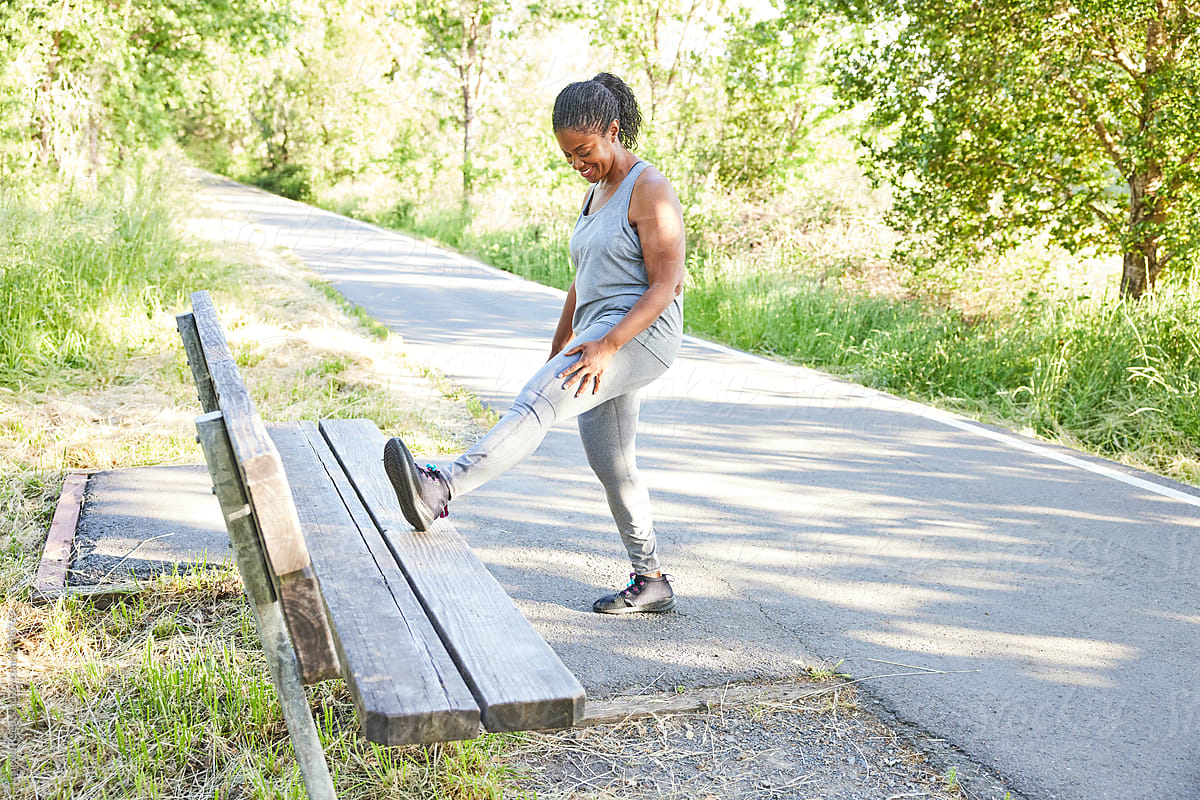 Mature Black woman stretching before going on a run in nature