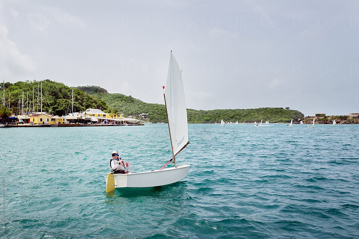 Boy in an optimist dinghy in English Harbour in Antigua