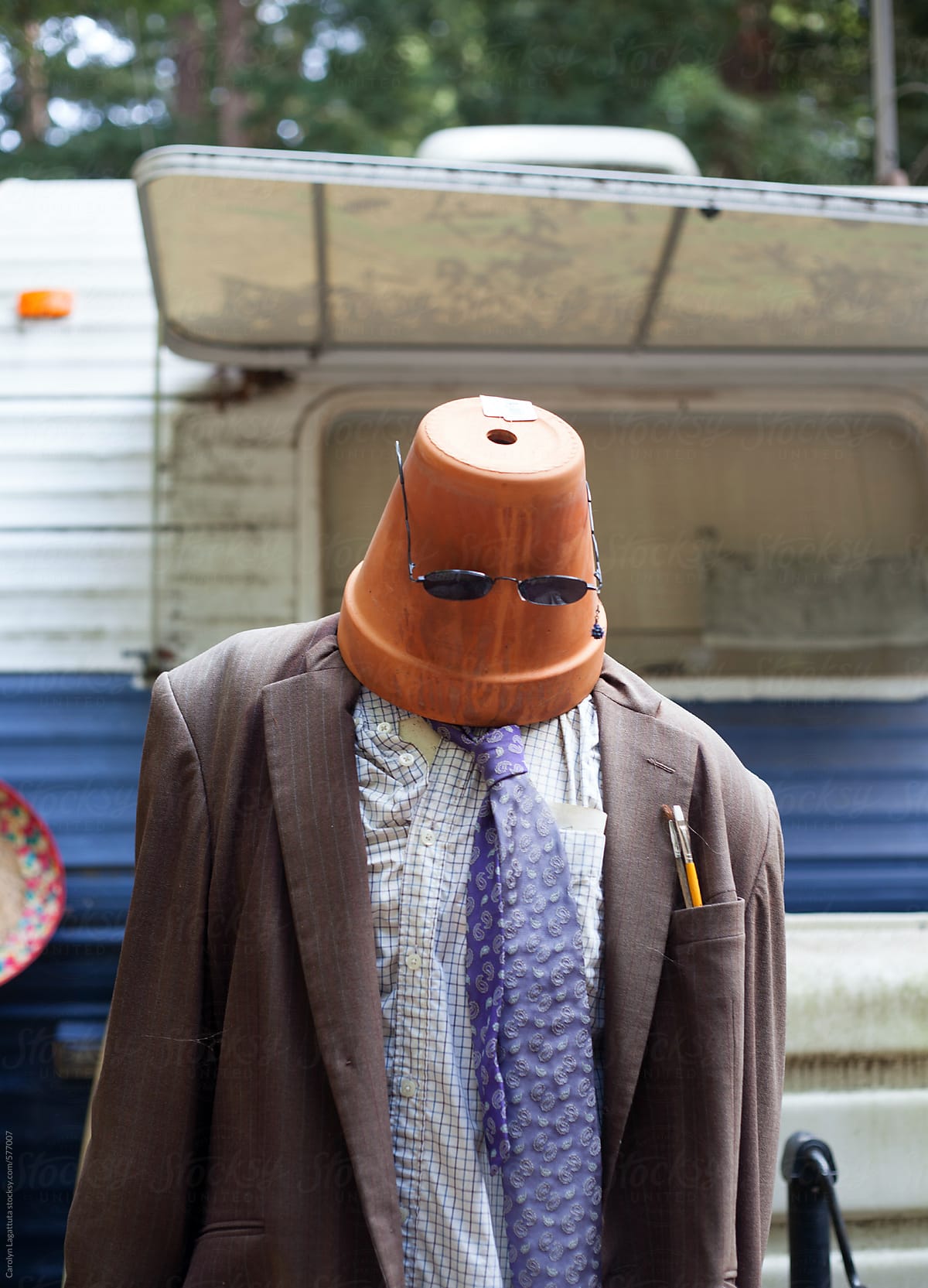 Man (or mannequin) in a trailer park with a pot on his head