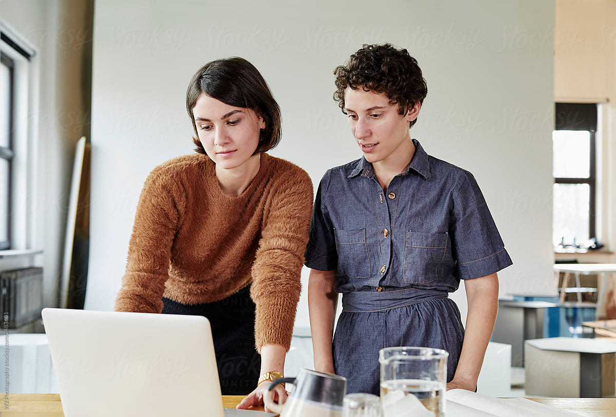 Two female coworkers working together in a modern design studio.