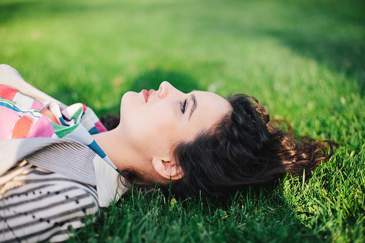 Beautiful Woman Lying On Grass In A Park By Stocksy Contributor