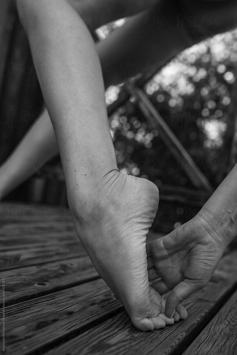 Monochrome photo of hand holding foot