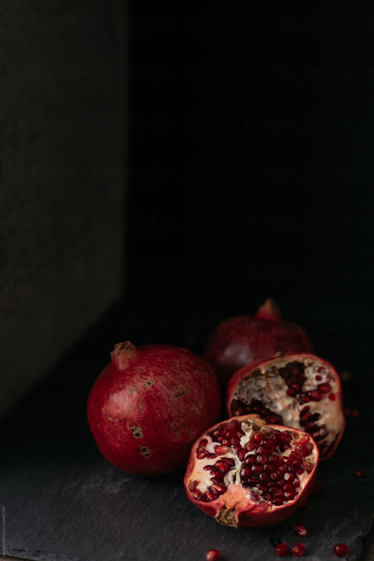 pomegranate seeds on wood table and slate
