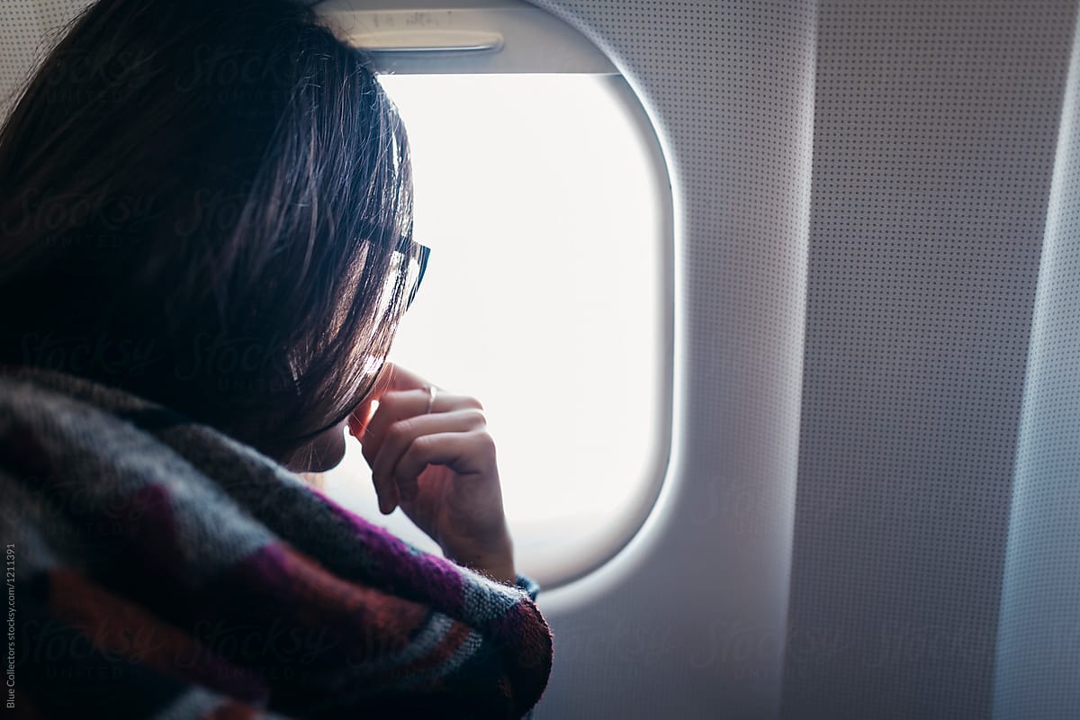 Woman watching through airplane window on land