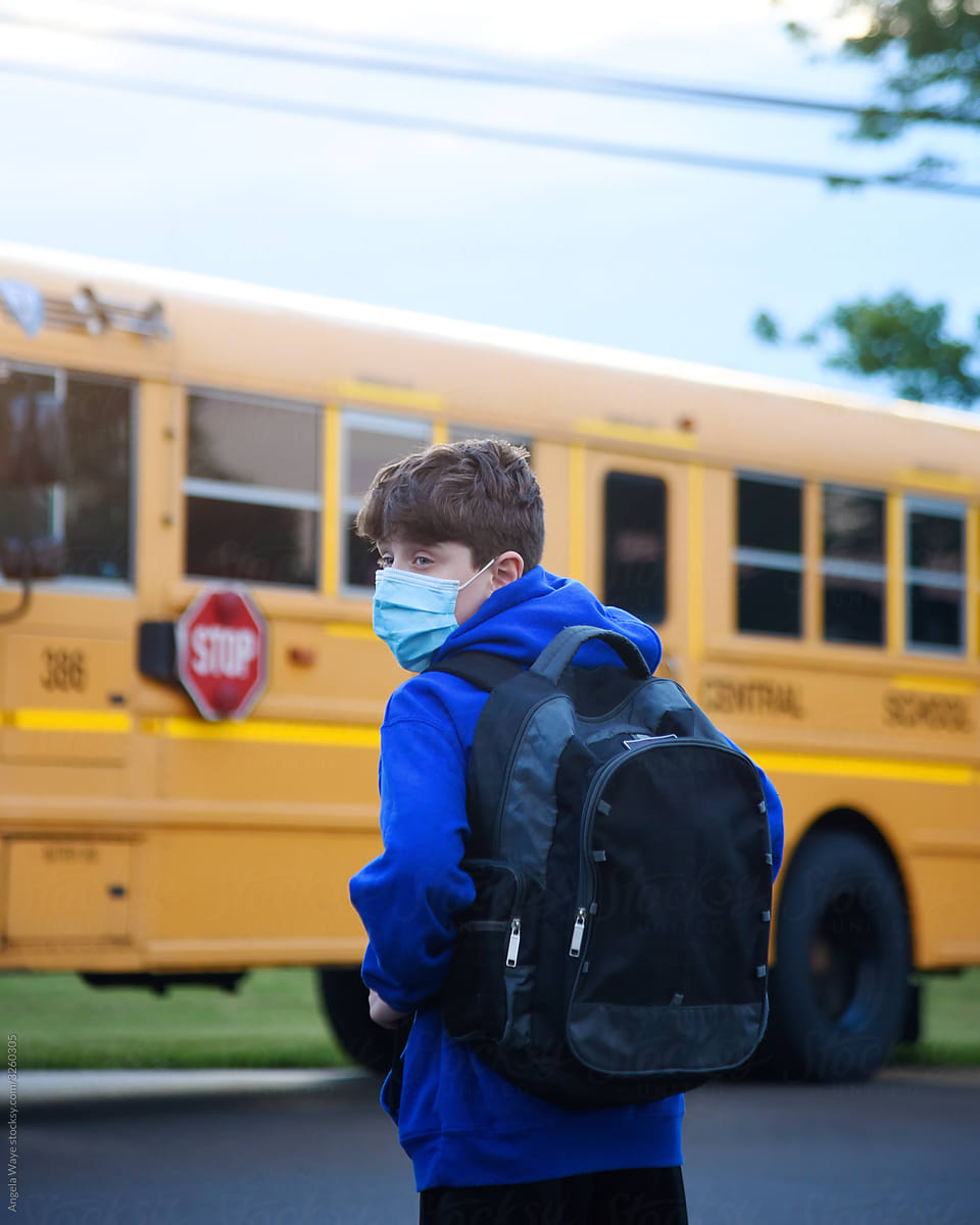 Student Wearing Virus Mask By School Bus
