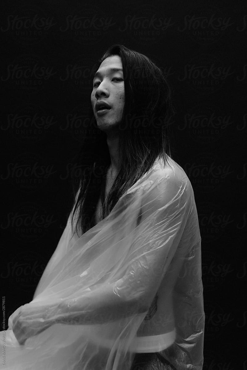 asian long haired man, dressed in plastic.