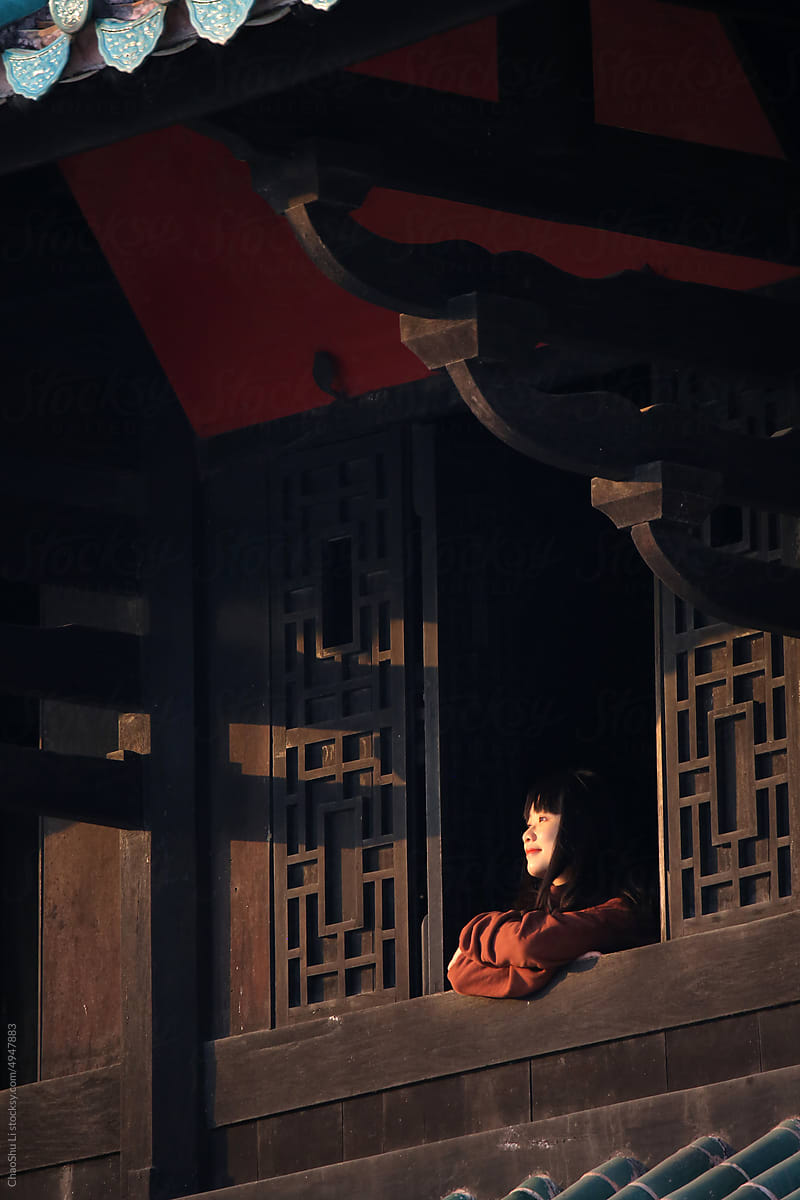 Asian lady in the attic of an ancient Chinese building