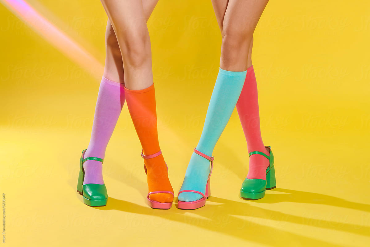 Female legs in mismatched trendy socks posing in fashionable