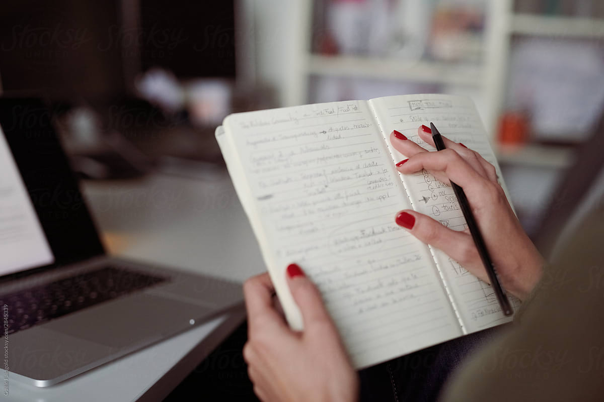 Female entrepreneur checking business plans in notebook