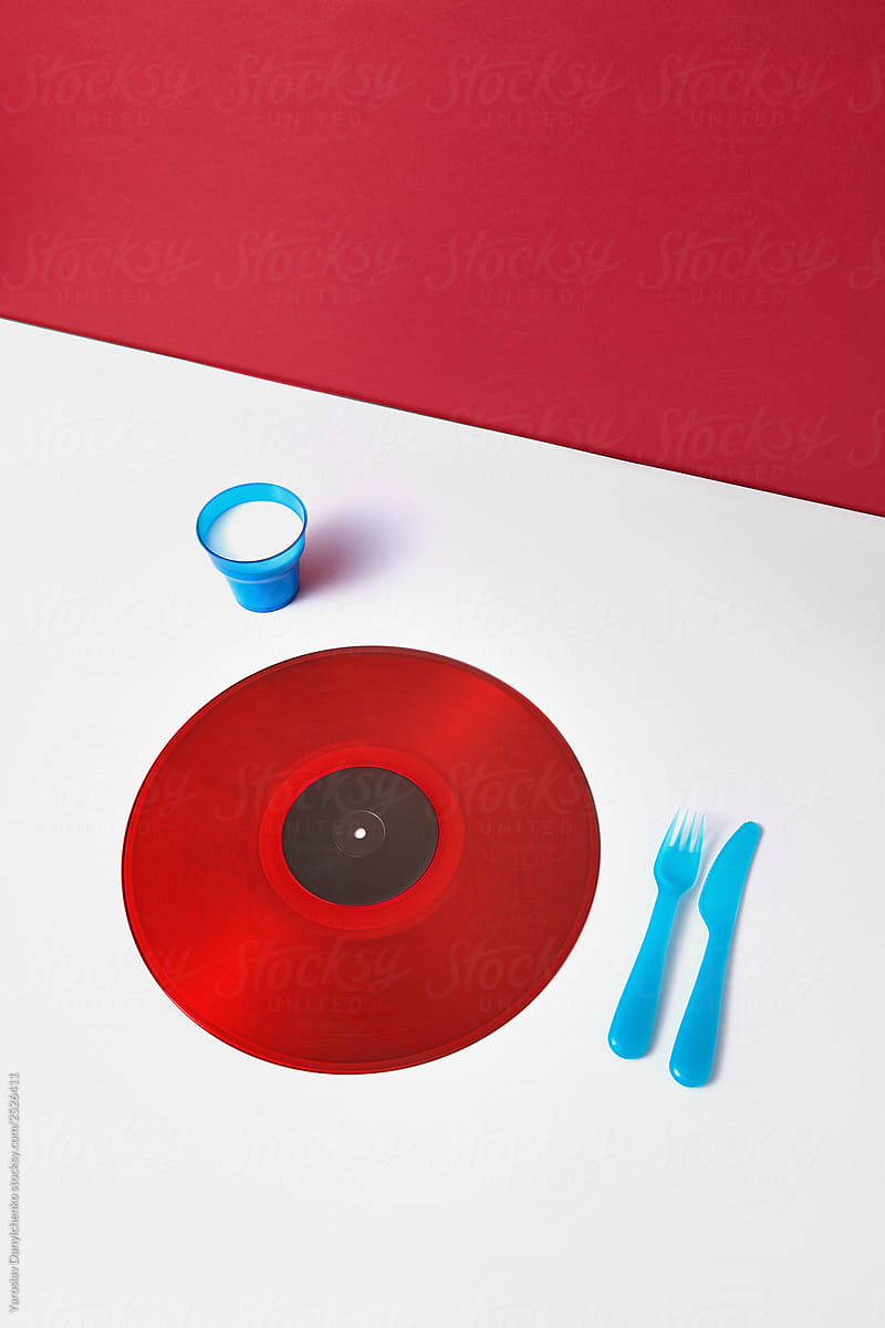 Vinyl record as a plate with plastic utensils on a duotone bacgr