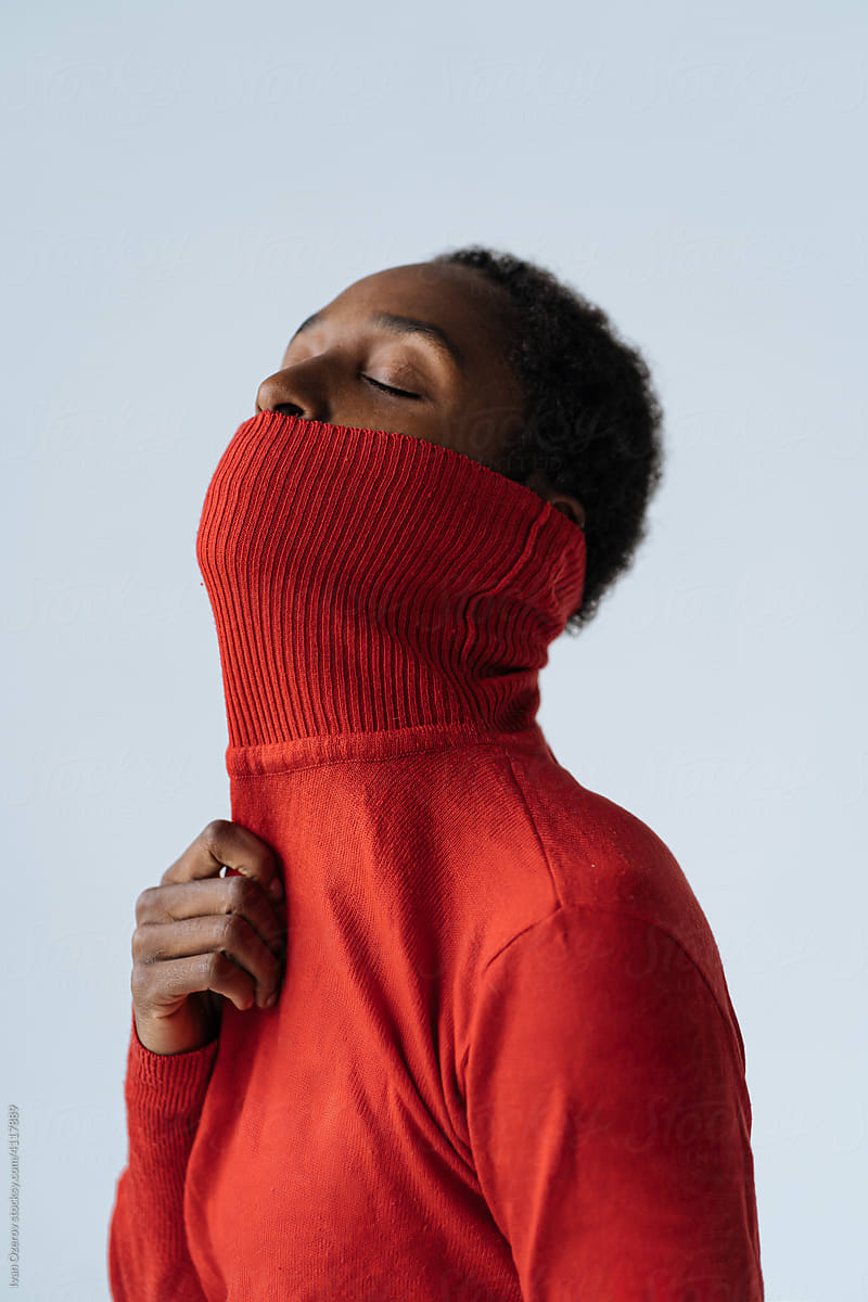 Black woman covering mouth with turtleneck