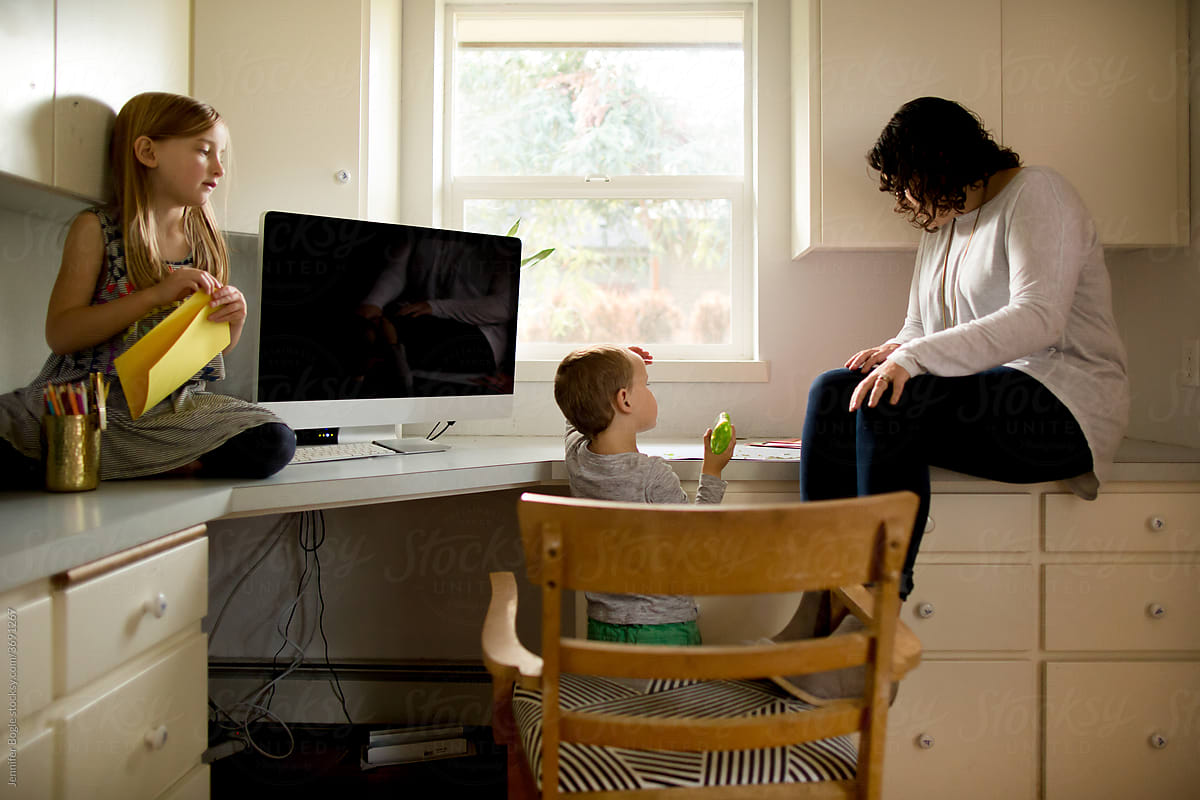Mother and children at home desk with computer