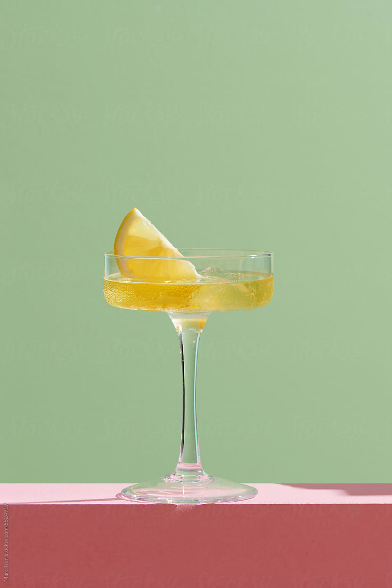 Glasses of tasty martini cocktail with lemon on light background
