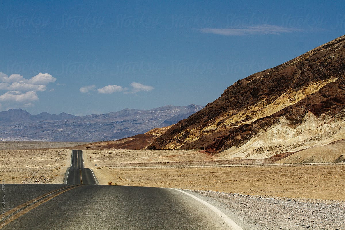 Long straight road through a hot empty desert valley