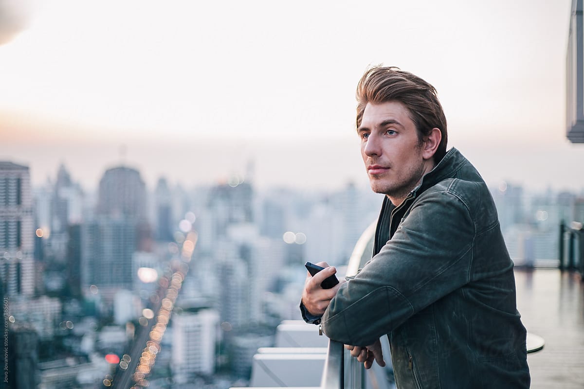 Stylish man looking at the city from rooftop