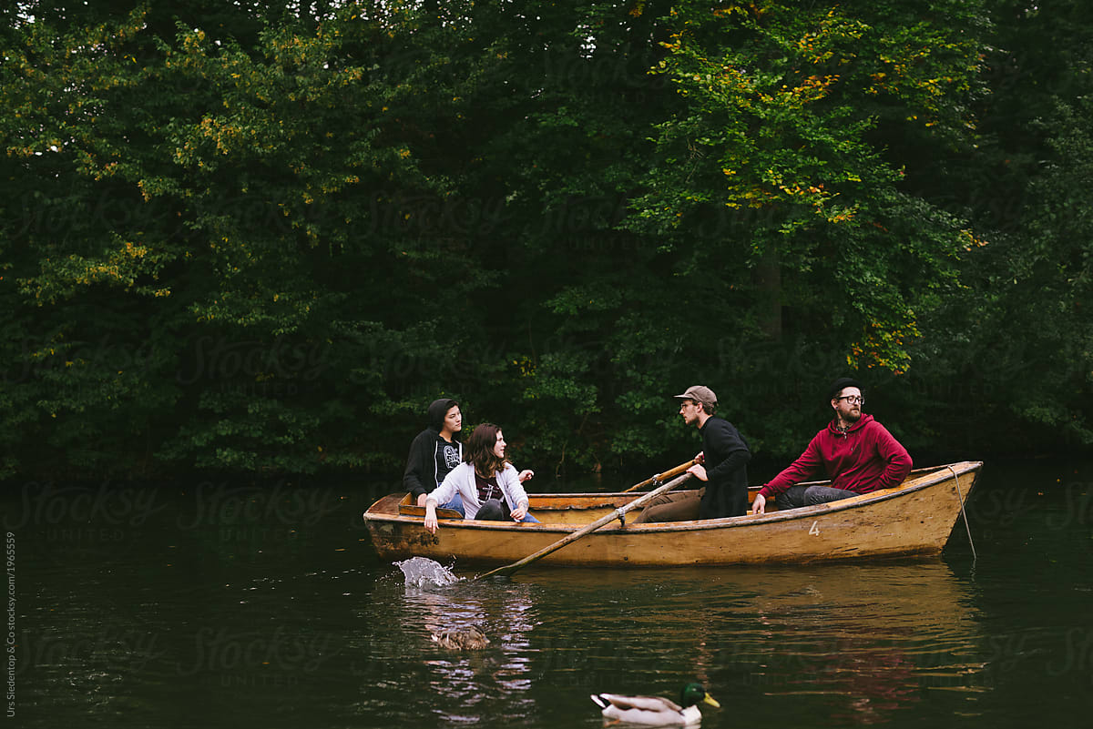 Group Of Friends In Wooden Boat by Stocksy Contributor Urs