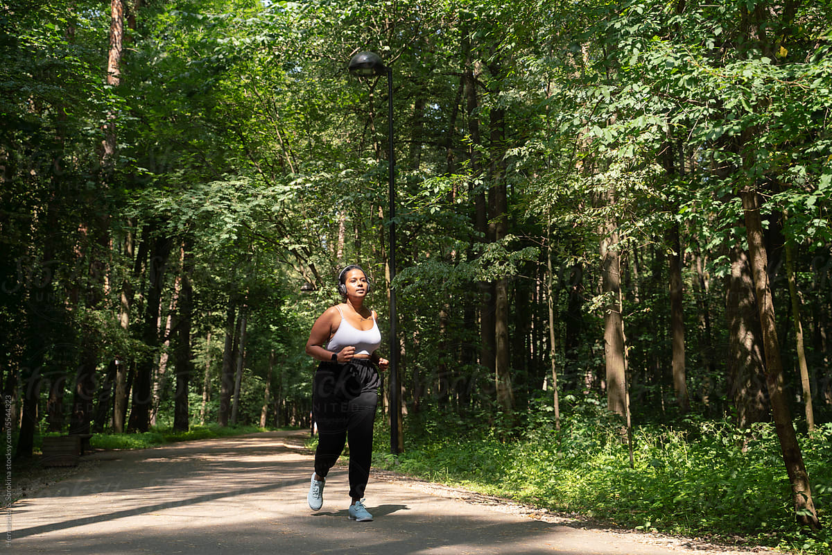 Plus Size Woman Running In The Forest