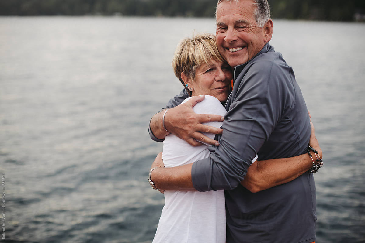 Fun Mature Couple Hugging Together On Dock At The Lake By Stocksy Contributor Rob And Julia