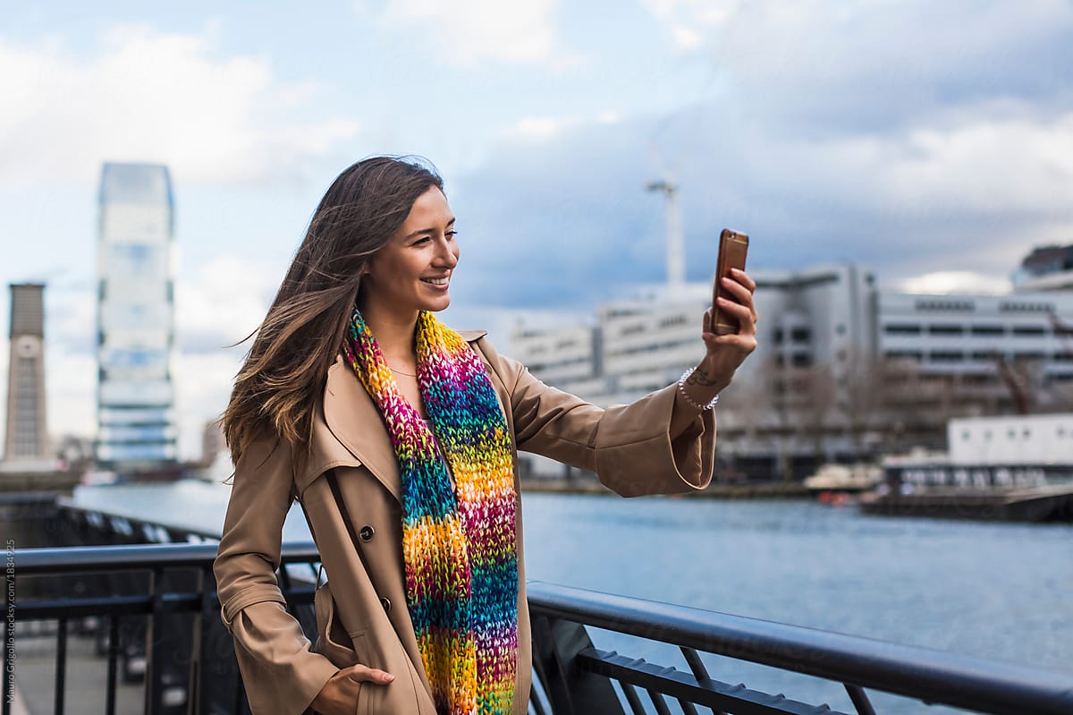 Happy woman takes pictures with her mobile phone