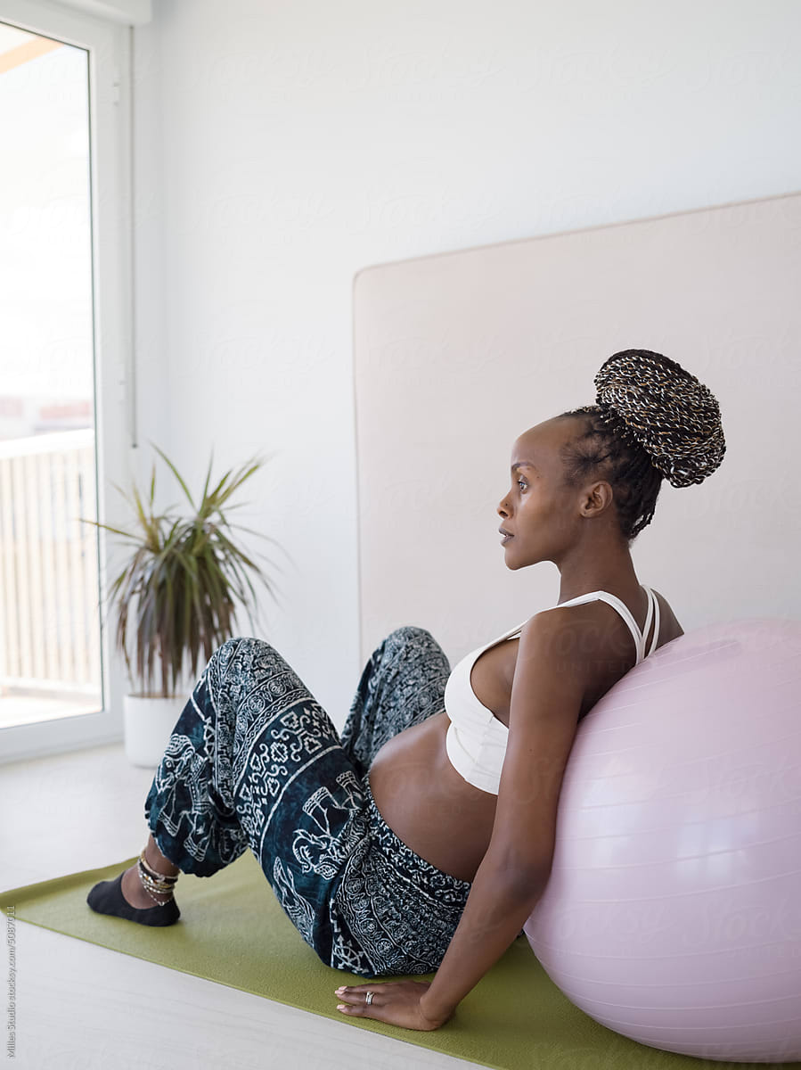 Dreamy pregnant woman during session with pilates ball