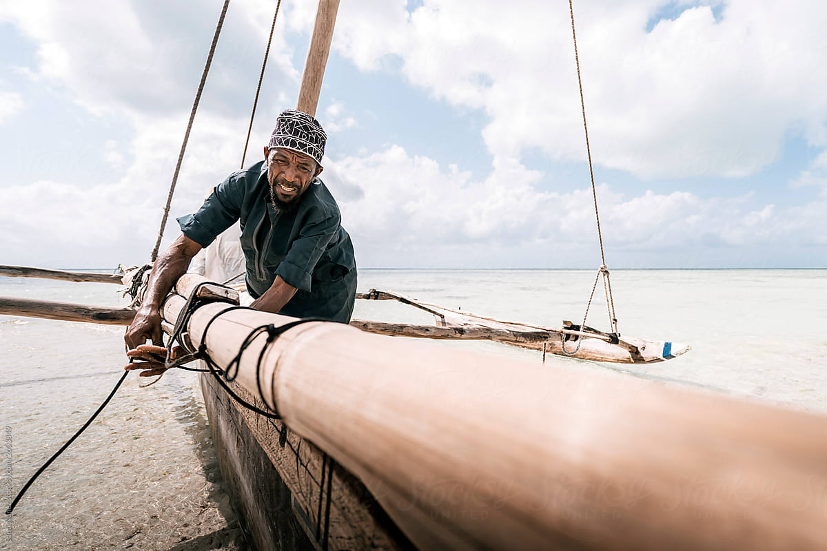 Zanzibari fisherman pulling rope, keeping balance to navigate hi