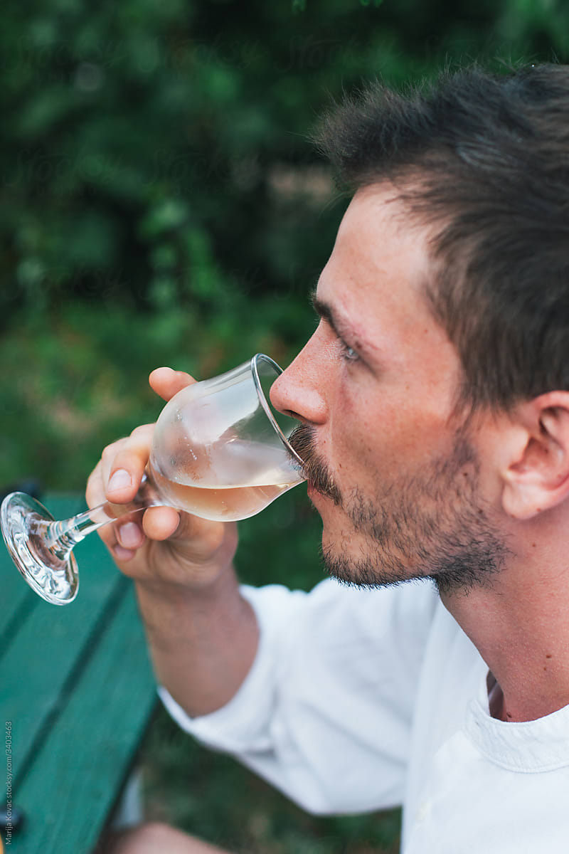 A man drinking white wine