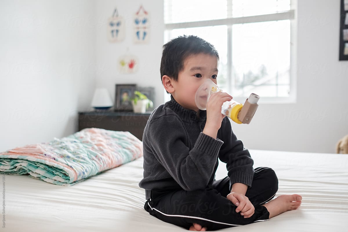 Asian Kid Using Asthma Inhaler Medication