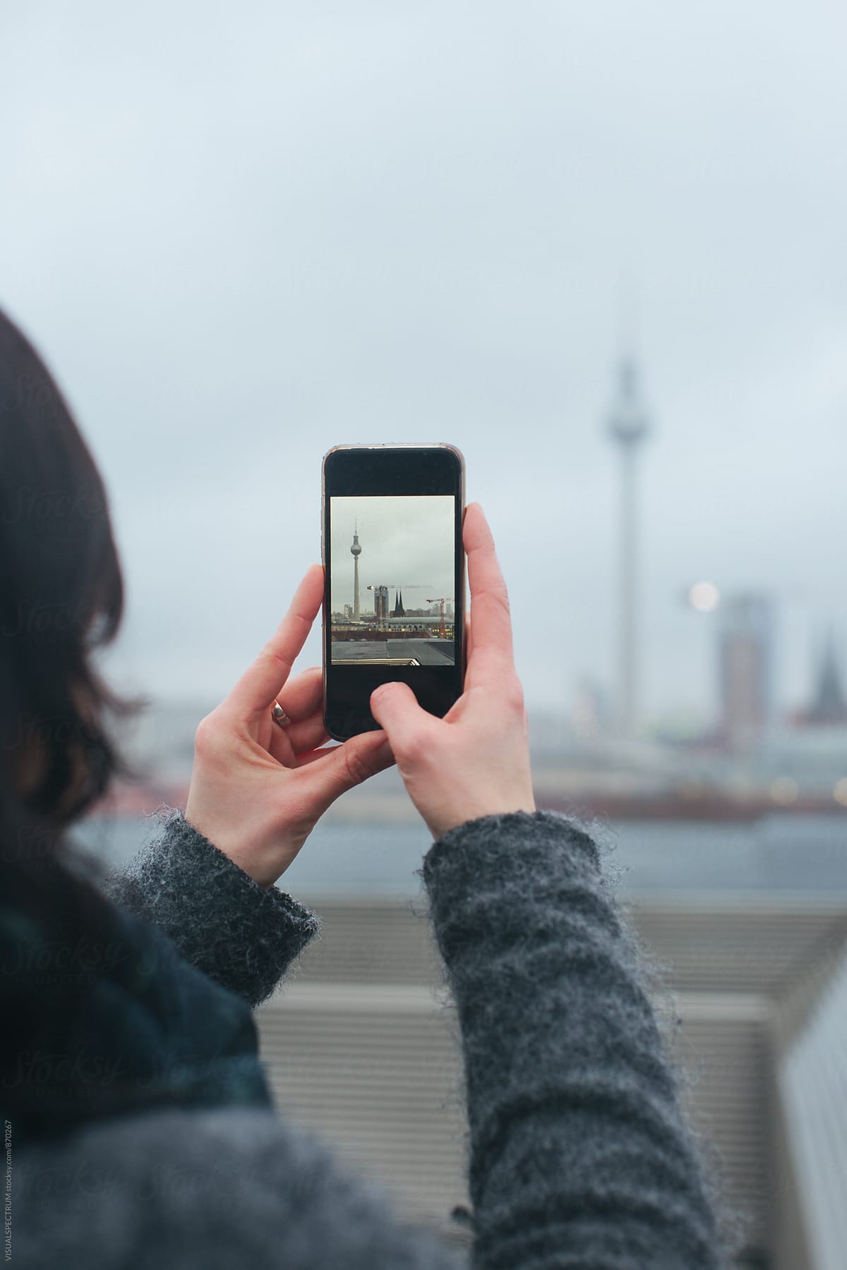 Detail of Woman Taking Smartphone Photo of Berlin\'s TV Tower on Rainy Winter Day
