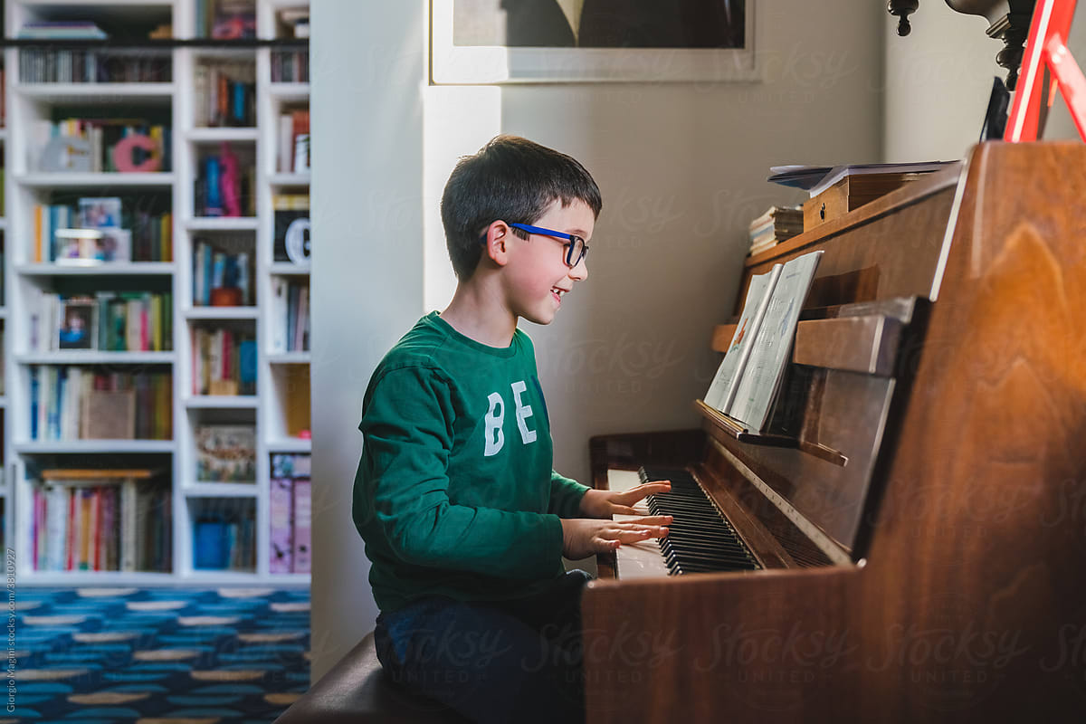 Happy Young Boy Playing Piano at Home