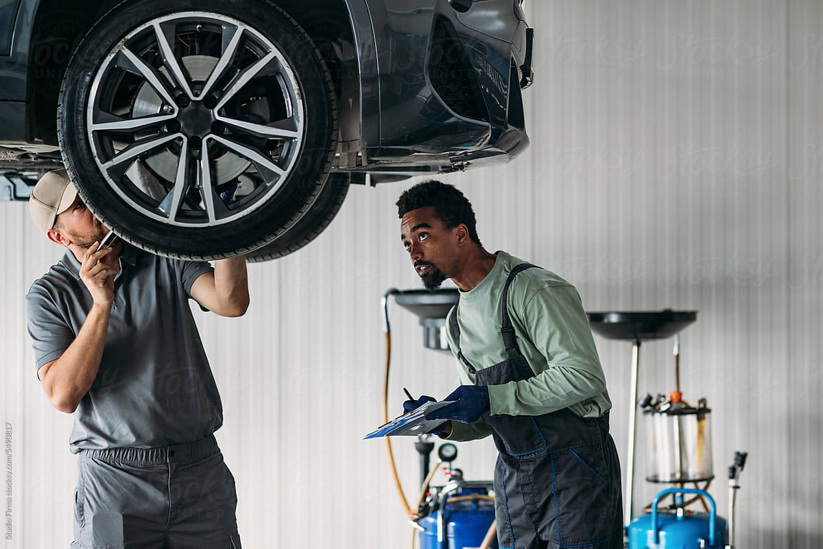 Two Mechanics Fixing Car in Garage