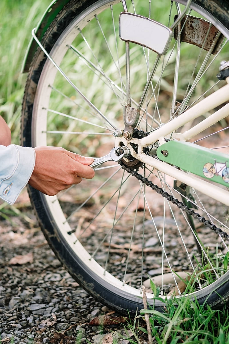 A woman\'s hand adjusting the tire of her bicycle.