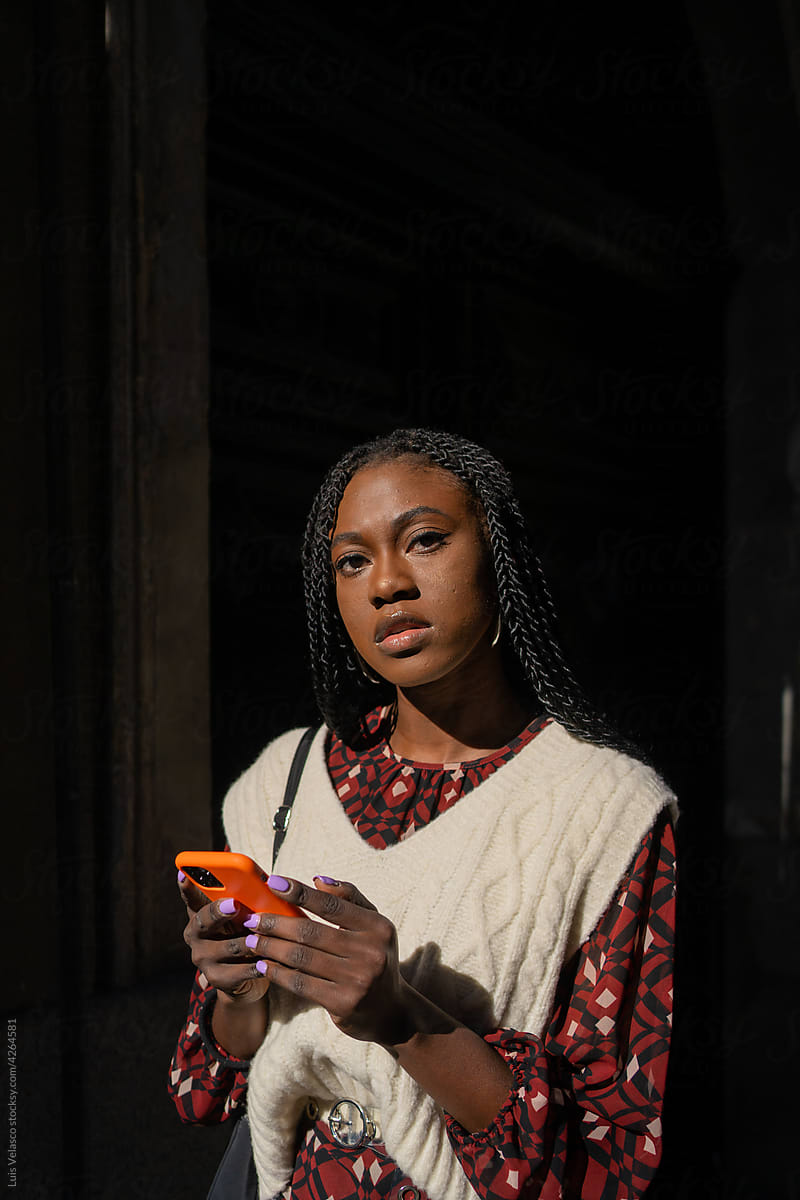 Portrait Of A Young Woman Holding A Phone On The Street