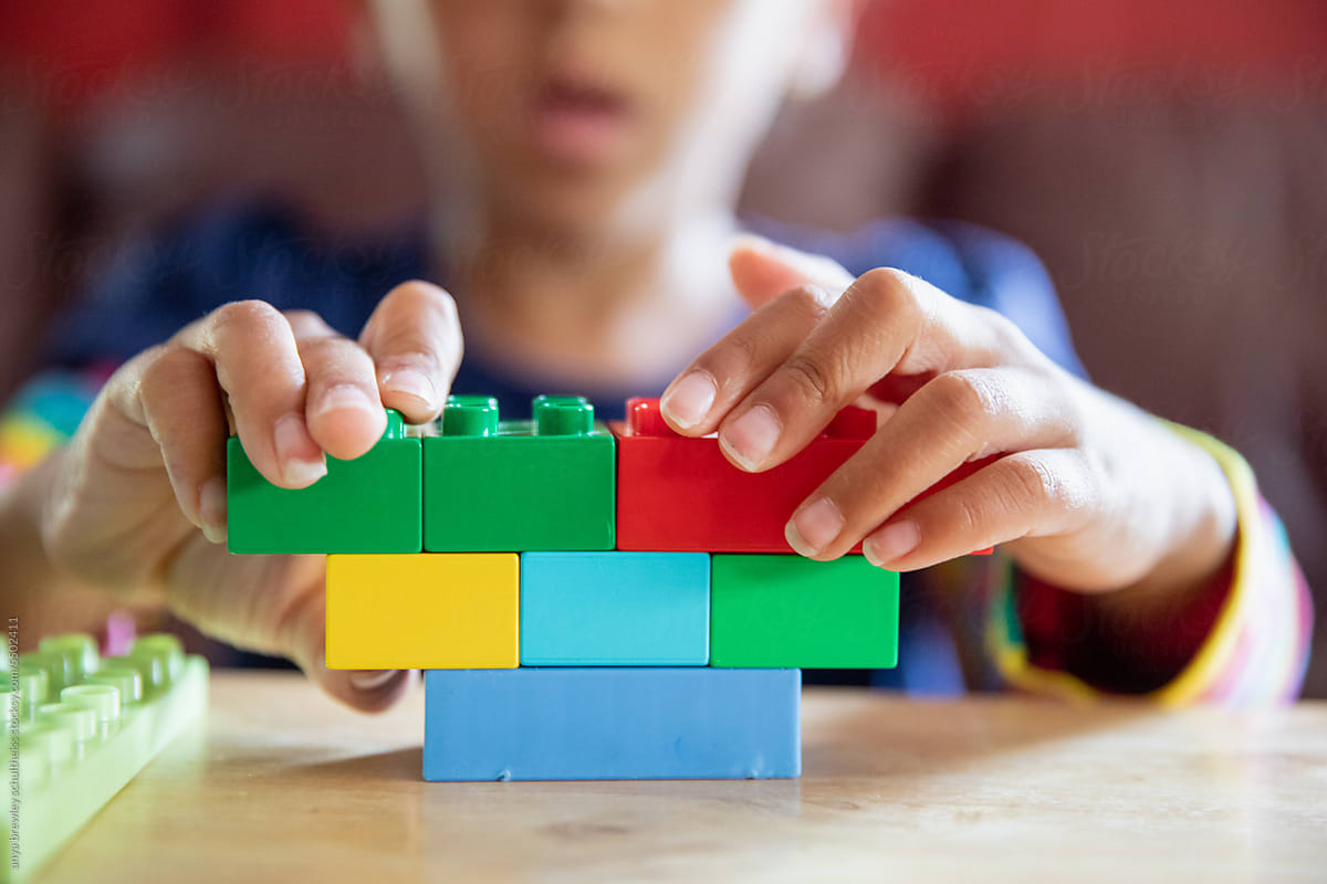 Closeup of lego blocks being assembled by a child
