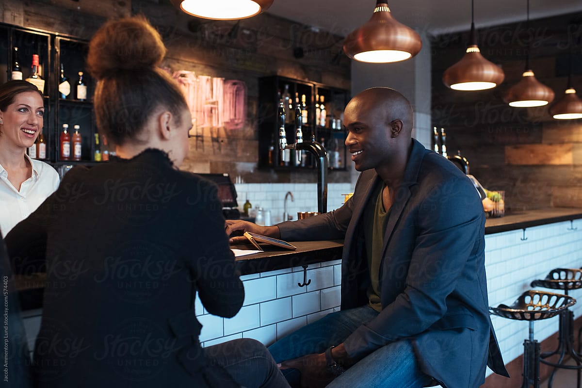 Young man sitting at bar counter with his female friend