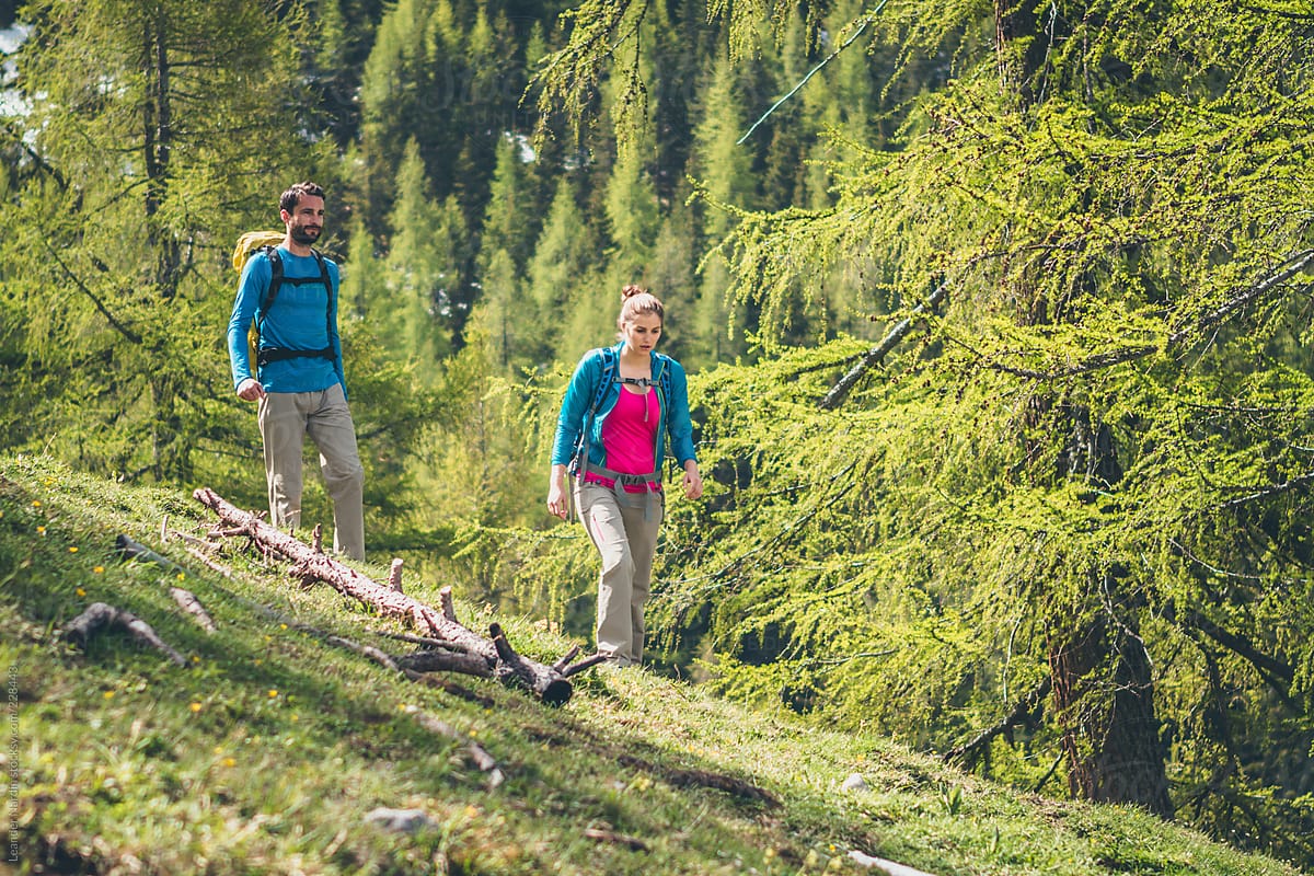 couple hiking through the forest in the austrian alps