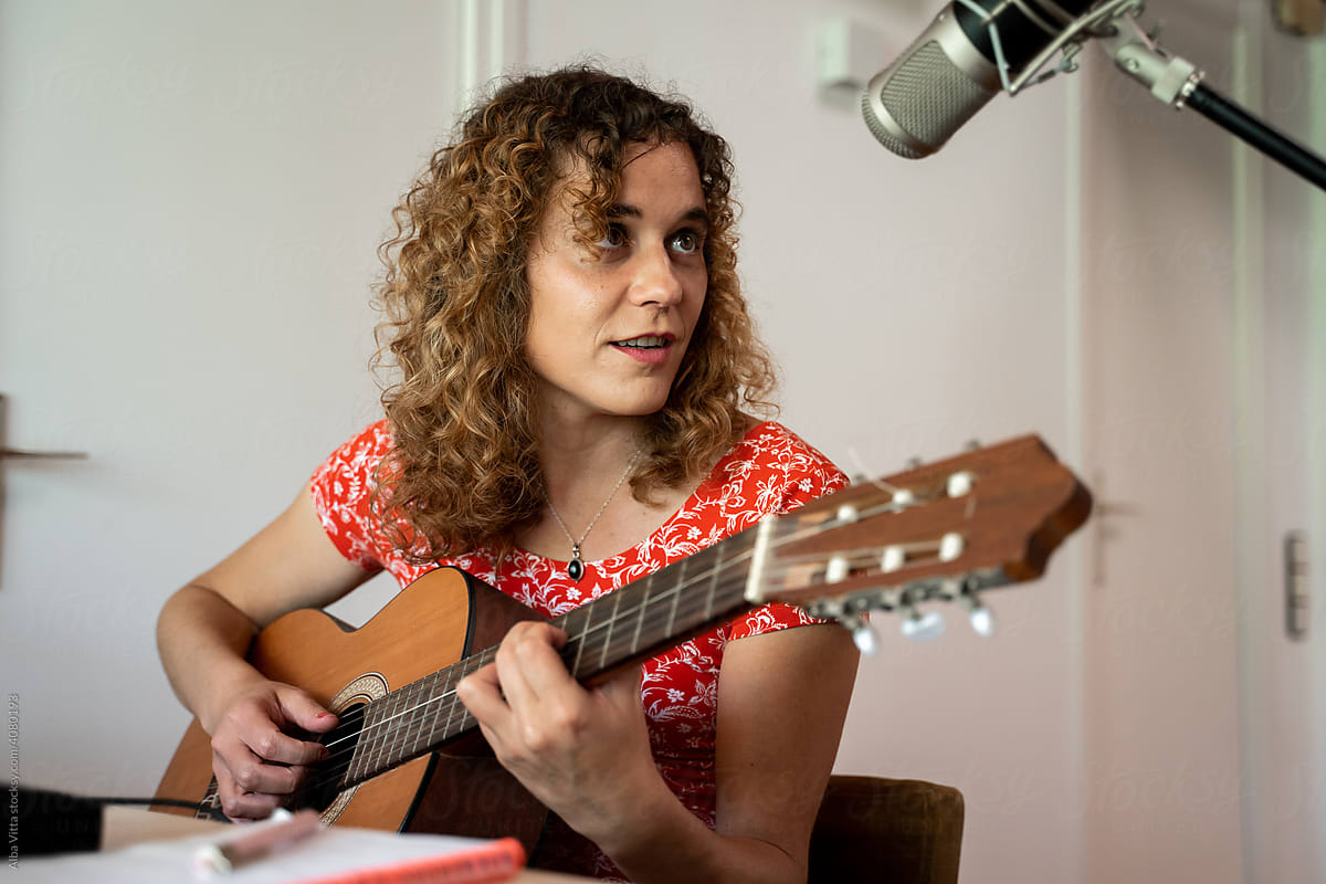 Woman playing and recording music at home studio
