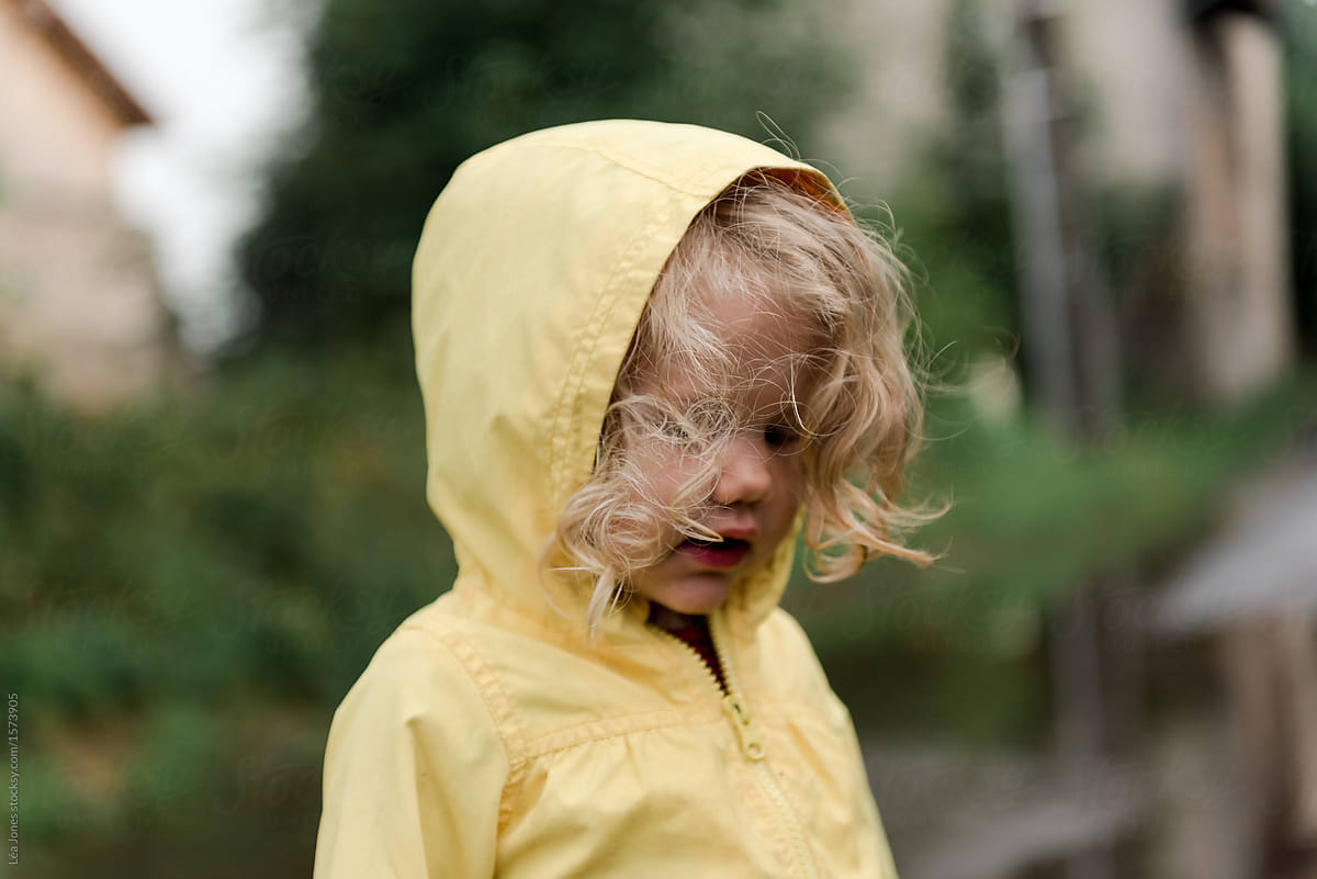 little girl with hood of yellow raincoat